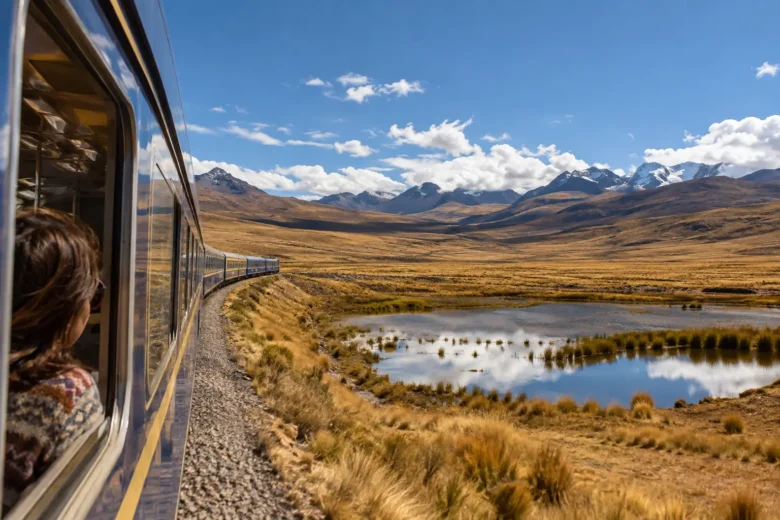 Trem atravessando o altiplano peruano entre montanhas e grandes horizontes